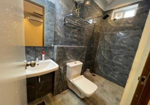 a bathroom with a toilet and a sink at The K Inn Wavefront in Mahabalipuram