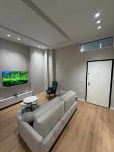 a living room with a couch and a flat screen tv at Apartment 27 in Elbasan +6 photos