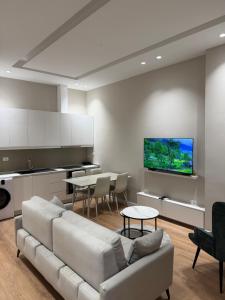 a living room with a white couch and a table at Apartment 27 in Elbasan