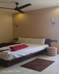 a bedroom with a bed with a ceiling fan at The K Inn Wavefront in Mahabalipuram