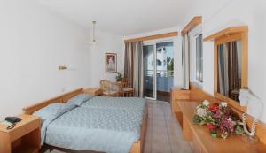 a hotel room with a bed and a balcony at Continental Palace in Psalidi +24 photos