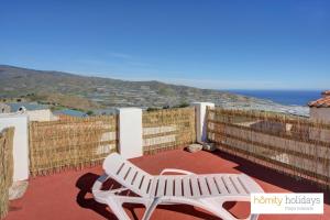 a white bench on a balcony with a view of the ocean at Homity Holidays - Gualchos - Casa Río Oculto in Gualchos