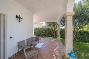 a patio with chairs and a table and a pillar at Hotiday Rooms Porto Rotondo in Porto Rotondo