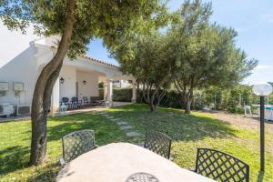 a table and chairs in the backyard of a house at Hotiday Rooms Porto Rotondo in Porto Rotondo