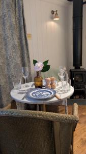 a dining room table with plates and glasses on it at The Applehay in Constantine
