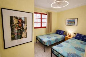 a bedroom with two beds and a picture on the wall at Sunny Playa del Cura in Playa del Cura +25 photos