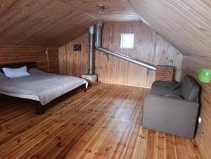 a bedroom with a bed and a couch in a attic at Гостьовий будинок з банею in Bohuslav +9 photos