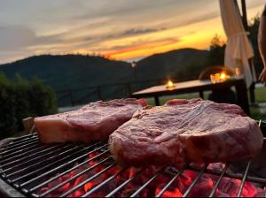 two pieces of meat are cooking on a grill at Borgo Macereto in Dicomano