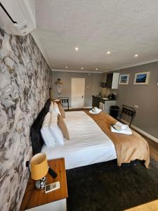 a bedroom with a large bed and a stone wall at The Golf Studio Woodhall Spa in Woodhall Spa
