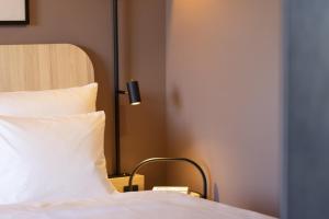a bedroom with a bed with a pillow and a lamp at Scandic Stuttgart Europaviertel in Stuttgart