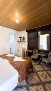 a bedroom with a bed and a table and chairs at Casa da Silvana in Fernando de Noronha