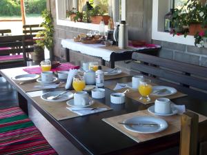 ein Tisch mit Tellern und Gläsern mit Orangensaft darauf in der Unterkunft Finca La Vertiente in El Encón