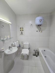 a bathroom with a toilet and a tub and a sink at نادي البحارة الدولي - International Seamans Club in Suez +30 photos