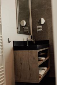 a bathroom with a black sink and a mirror at Hotel Tholen in Tholen