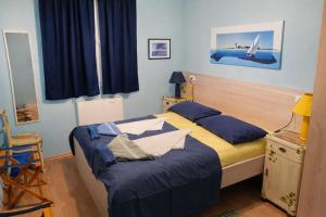 a bedroom with a bed with blue sheets at Apartments Vila Vino in Sveta Nedelja