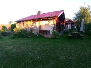 Ein Haus mit einem Picknicktisch und einem Sonnenschirm im Garten in der Unterkunft Biehlerhof in Freudenberg
