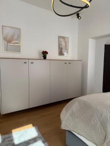 a white bedroom with white cabinets and a bed at Odpocznij w Centrum in Wałbrzych
