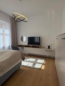 a bedroom with a bed and a flat screen tv at Odpocznij w Centrum in Wałbrzych