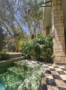 a house with a swimming pool with a checkered floor at Villa La Drianké in Dakar