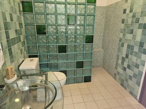 a bathroom with a toilet and a glass sink at Villa La Drianké in Dakar