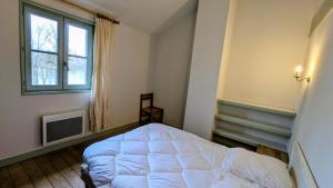 ein Schlafzimmer mit einem weißen Bett und einem Fenster in der Unterkunft Basse roche in Meuzac