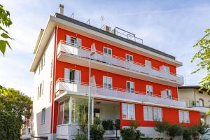 an orange and white building with a balcony at Rabbit Home in Misano Adriatico