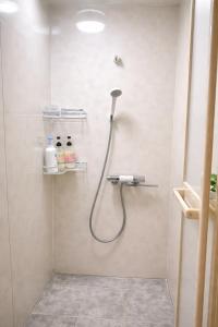a shower with a hose in a bathroom at 竹の宿b湖まで徒歩4分の好立地最大7人宿泊可能 in Fujikawaguchiko