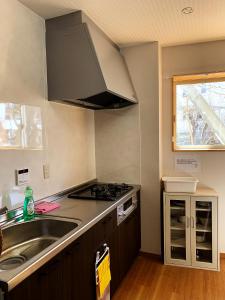 a kitchen with a sink and a stove at 竹の宿b湖まで徒歩4分の好立地最大7人宿泊可能 in Fujikawaguchiko +11 photos