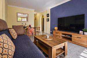 a living room with a couch and a large television at Sunny Playa del Cura in Playa del Cura