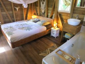 a bedroom with a bed and a sink and a tub at Cabane Autentikaz in Saint-François +3 photos