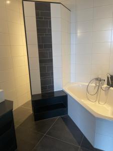 a bathroom with a bath tub and a mirror at De Peelrand Hoeve in Venhorst +25 photos