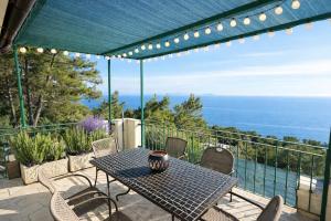 a table and chairs on a patio with a view of the ocean at Apartments Vila Vino in Sveta Nedelja