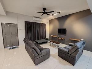 a living room with two couches and a flat screen tv at ipohbnb Bercham HomeStay in Ipoh