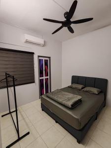 a bedroom with a bed with a ceiling fan at ipohbnb Bercham HomeStay in Ipoh