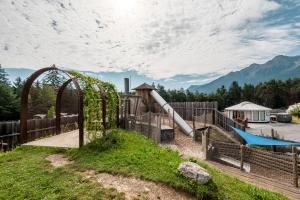 a park with a playground with a slide at Tirol Cabin by ALPAMI in Wildermieming