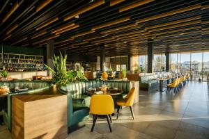 a restaurant with yellow chairs and tables at mk hotel tirana in Tirana