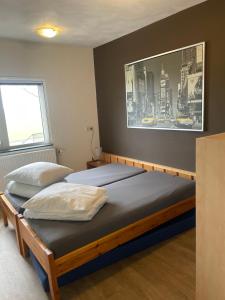 two beds in a bedroom with a picture on the wall at De Peelrand Hoeve in Venhorst