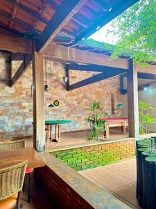 a patio with a table and chairs and a brick wall at Pousada Solar dos Guarás in Catas Altas