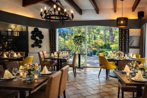 a restaurant with tables and chairs and a large window at Logis Hotel Le Lac in Embrun