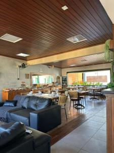 a living room with a couch and tables and chairs at Pousada Solar dos Guarás in Catas Altas