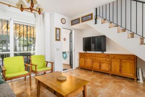 a living room with a tv and a staircase at Balconera 104 in Novo Sancti Petri