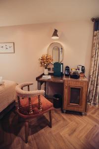 a bedroom with a bed and a desk with a chair at The Fountaine Inn in Linton