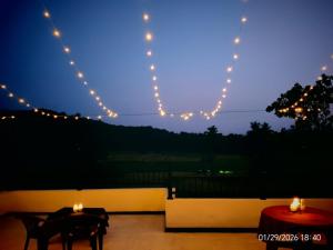 a patio with two tables and lights in the sky at The Paddy Breeze Villa in Marukwatura +9 photos