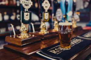 a glass of beer sitting on a bar at The Fountaine Inn in Linton