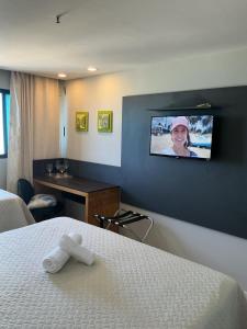 a hotel room with a bed and a tv on the wall at Apartamento 1307 QUALITY HOTEL in Natal