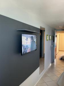 a flat screen tv on a wall in a living room at Apartamento 1307 QUALITY HOTEL in Natal