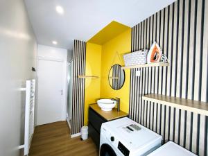 a bathroom with a yellow and black wall at maison cosy proche du port et plage in Grand-Fort-Philippe +20 photos