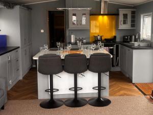 a kitchen with a table with wine glasses on it at Whitstable Beaumont - Sleeps 6, 588 ft in Seasalter