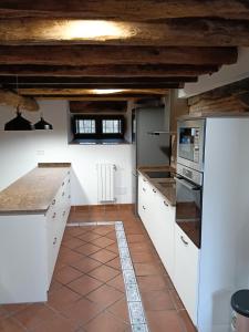 a kitchen with white cabinets and a tile floor at ALOJAMIENTO MONTE EDILLA Naturaleza, Confort y Recarga Eléctrica in Quintana de los Prados