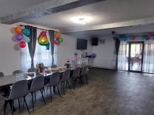 a dining room with a table and chairs and balloons at Vila Narci Paltinis in Păltiniş